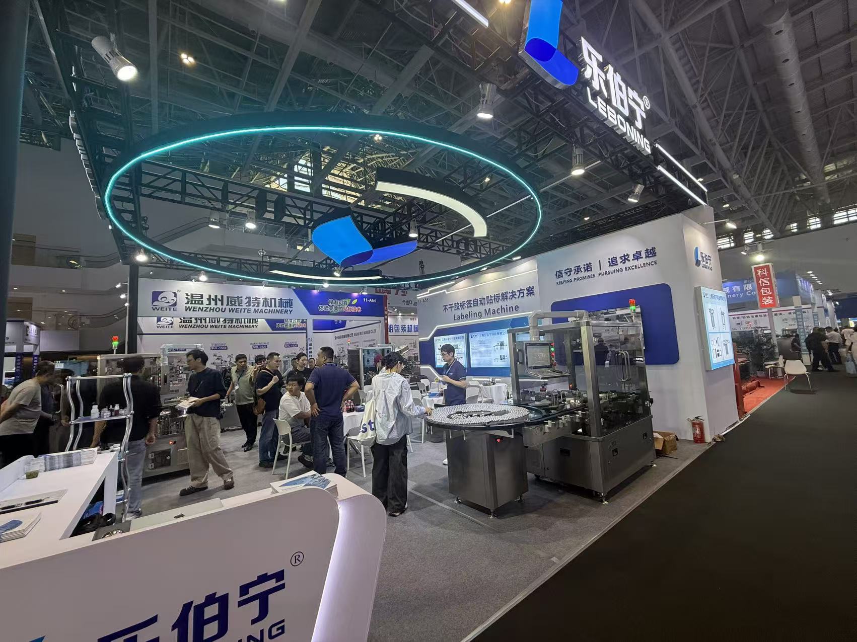 Wide view of the LEBONING booth beneath an illuminated circular sign
