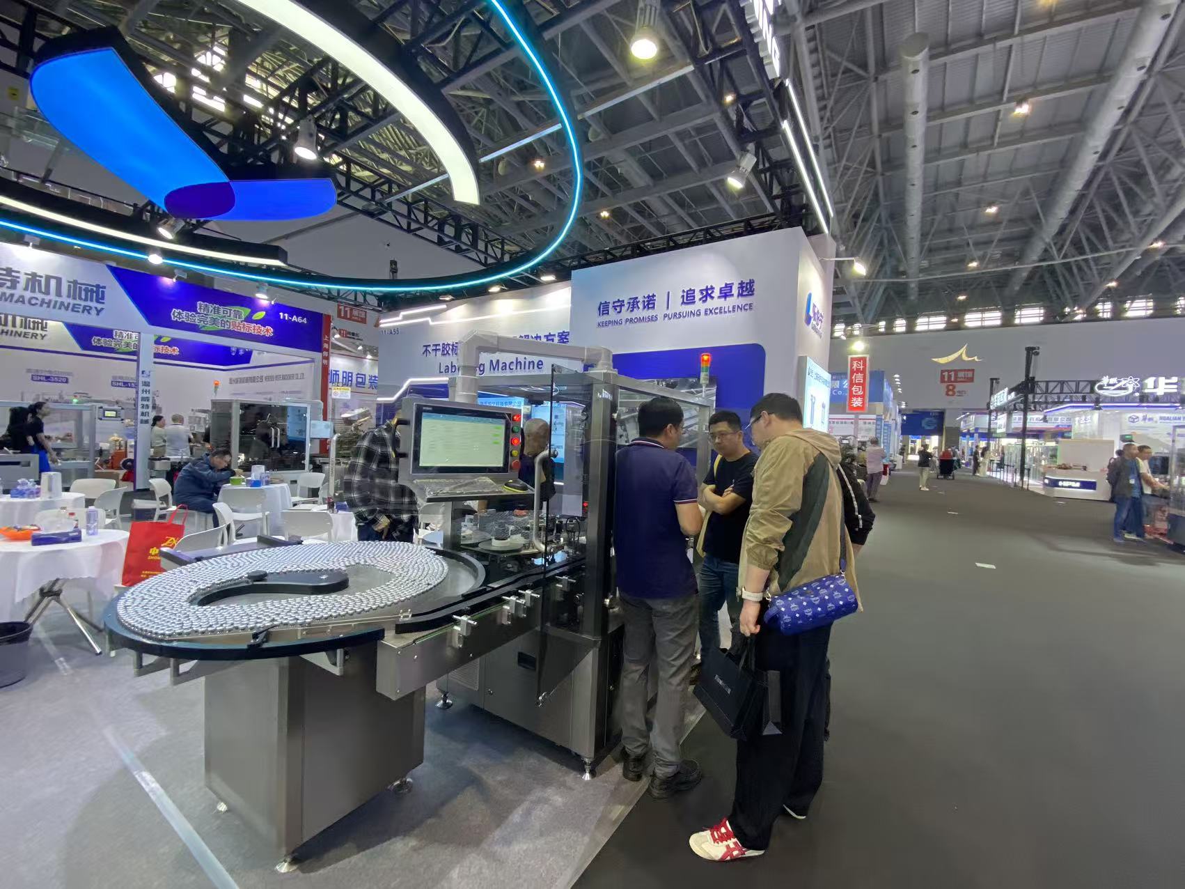 Visitors and a LEBONING team member beside the vial table and machine control screen